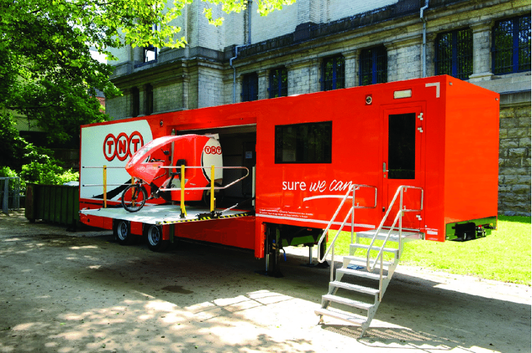 Small container unit in Brussels serving as a mobile depot, with a dock, sorting
center, office space, and a lift that allows cargo e-bikes to easily access parcels.