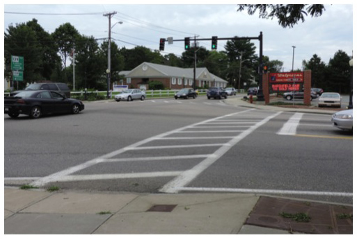 Figure 3 is titled “Intersection Overview: Eastbound Approach.” It is a photograph taken from the perspective of an eastbound driver approaching the traffic signal at the intersection. 